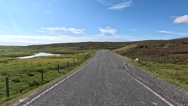 Lonely road snakes through a vast, hilly landscape with clear skies, Mainland, Shetland Islands, Shetlands, Scotland, Great Britain