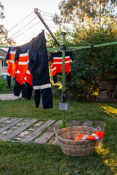 Australian backyard scene of clothesline with hi vis workwear hanging on washing line
