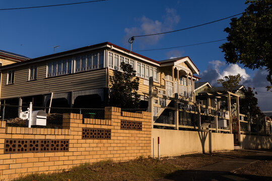 Elevated house with timber cladding bathed in warm late-afternoon sunlight