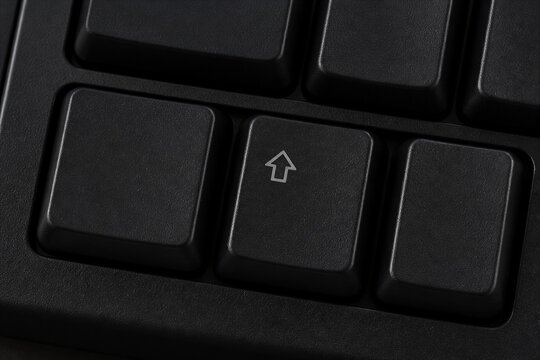 Keyboard shift key closeup on black textured surface
