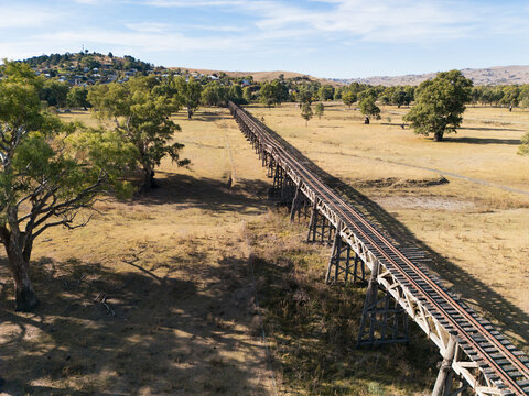 Aerial view of a wooden disused railway bridge crossing floodplains in Gundagai