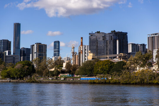 view from the Brisbane river with industrial area in the foreground and city buildings behind