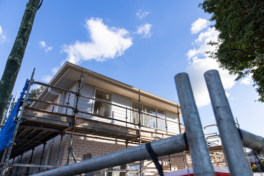 scaffolding and temporary fencing around a new home getting built