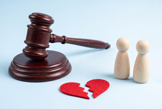 Judge's Gavel and Broken Red Heart Beside Wooden Couple Figures on Blue Background Divorce Concept
