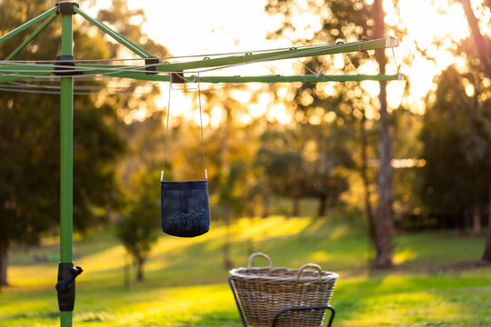 Australian backyard scene of washing line with peg bag and washing basket at sunset