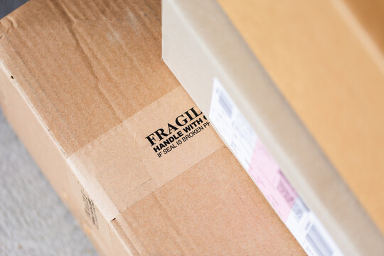 Cardboard boxes with fragile on tape by door of house from online home delivery orders