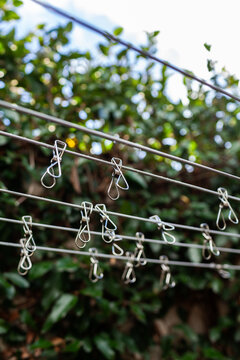 Metal pegs hanging on clothesline wires in aussie backyard