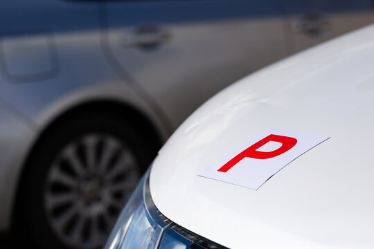 Magnetic red p plate for provisional license holder driver on car parked on driveway