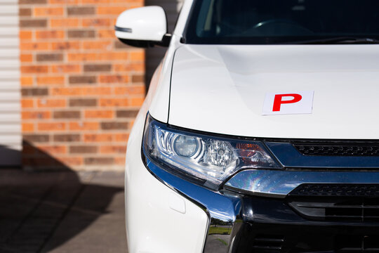 Magnetic red p plate for provisional license holder driver on car parked on driveway
