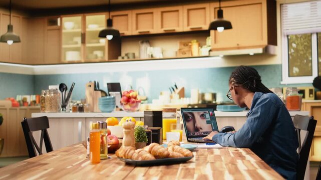 Woman graphic designer retouches photos on laptop with color correction software, using image processing and visual effects to enhance photography.