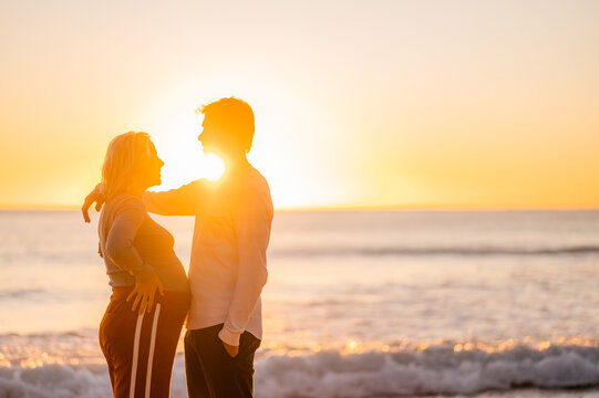 Pregnant couple enjoying sunrise at Manly Beach