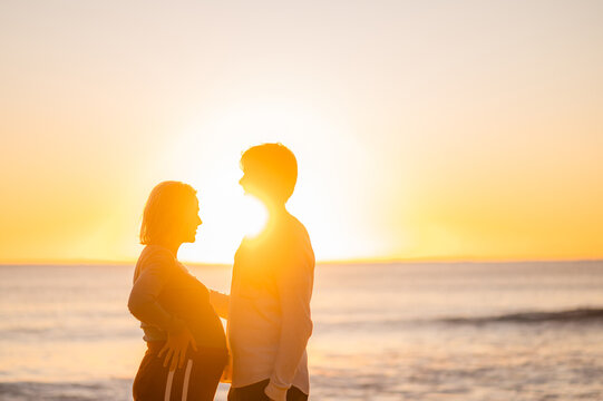 Couple enjoying sunrise at Manly Beach during pregnancy