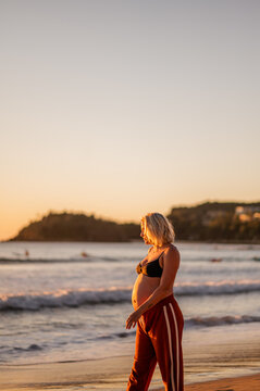 pregnant woman by the beach at sunrise