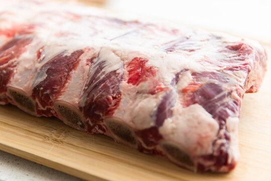 beef ribs with cut bones on a chopping board
