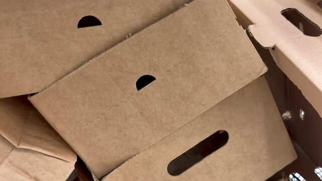 Close-up view of empty brown cardboard boxes folded and stacked together. Packaging material, storage box, shipping container.