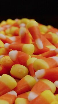 Candy corn falling into pile in slow motion vertical video