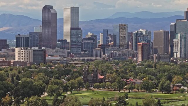 Denver skyline with urban buildings, green park, and distant mountain range