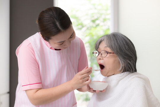 訪問介護で高齢者の食事介助をするホームヘルパー、在宅介護、食事支援、食べることをサポートするイメージ