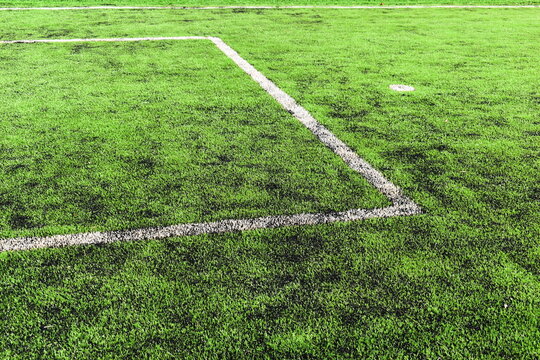 green synthetic grass field texture with white boundary line for sport background