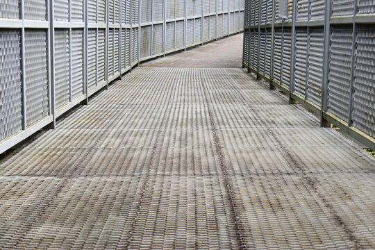 steel mesh canopy walk bridge walkway extending into green jungle