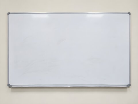 Wall mounted whiteboard with aluminium frame and marker tray in a tuition room with faint grey smudges on a clean white surface