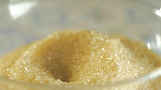 Person Scooping Brown Sugar With a Spoon &mdash; Close-Up Food Ingredient