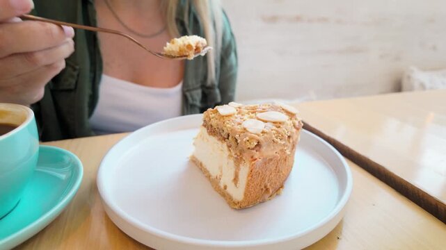 Close-up of woman eating creamy cheesecake at cafe table - Coffee shop dessert, gluten free and healthy treat lifestyle concept