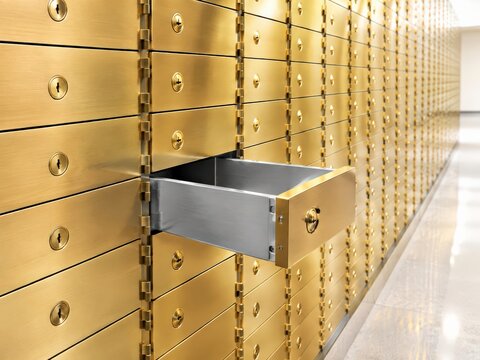 Single safe deposit box drawer pulled out from a wall of brass doors in daylight, showcasing a clean and sharp focus