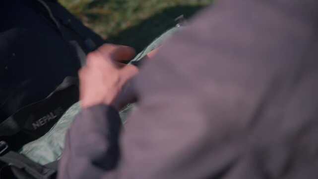A man affectionately hugs his dog on the ground in a bonding moment, later gazing at a rocky outcrop wearing a cap.