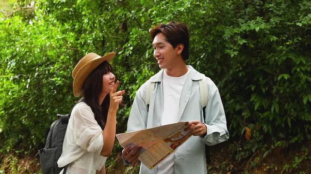 Young Asian Couple Hiking and Reading Map in Lush Green Forest