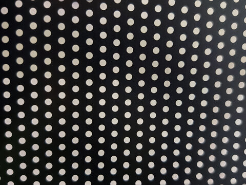 a dark perforated surface with bright circular holes arranged in a regular geometric grid. Suitable as a seamless background for modern industrial design templates, technology backdrops, or minimalist