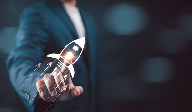 Businessman touching on rocket launch with up arrow, investment growth, planning and starting corporate business start up aiming objective value development leadership and customer target group.