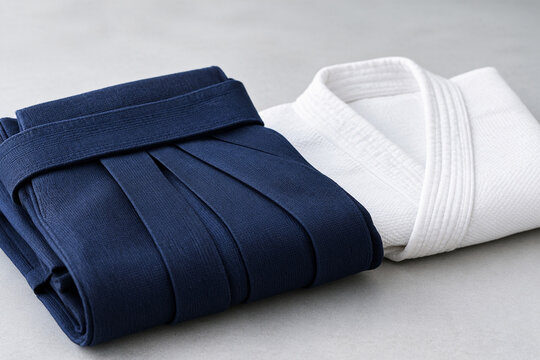 Folded indigo hakama and white keikogi cloth on table, martial arts tradition and textile concept