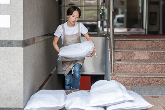 土嚢を積む女性