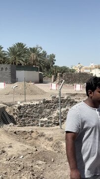 Man walking through a sunny outdoor construction and excavation site in Saudi Arabia.