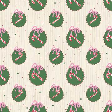 Seamless Christmas pattern with green wreaths, pink bows and candy cane on pastel background. Vector illustration for winter holiday fabric textile print, wrapping paper, and greeting cards.