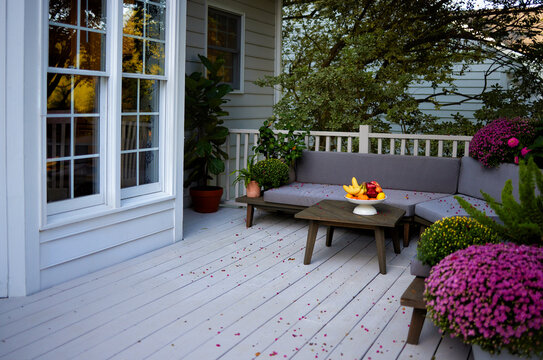 Cozy fall patio with outdoor seating, colorful chrysanthemums and fresh fruit