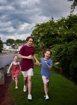 Happy children laughing and running together in warm summer rain