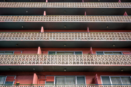 Old Pink Residential Building with White Cinderblock Railings.