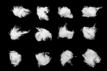 Twelve small white cotton wool pieces arranged in a neat grid on a deep black background, showing soft fiber texture and isolated copy space. © Mukta