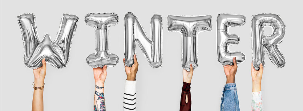 Hands holding balloons spelling Winter