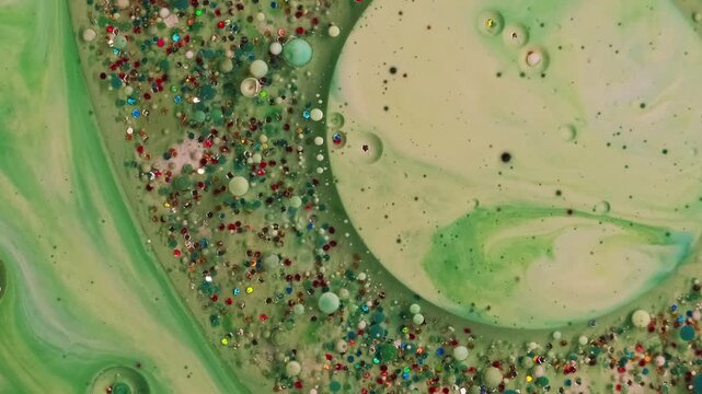 Paint fluid. Oil ink bubbles. Defocused green blue color water vibrant sequins splash round texture floating on abstract acrylic art background.