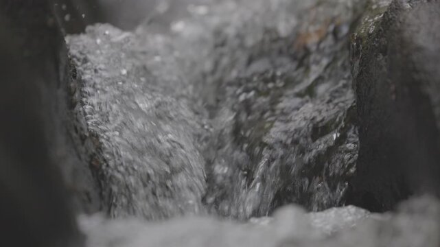 Clear mountain stream with pure water flowing and bubbling over natural in a pristine wilderness environment, dynamic motion of fresh transparent water. ProRes 422 10 bit, raw C-LOG video.
