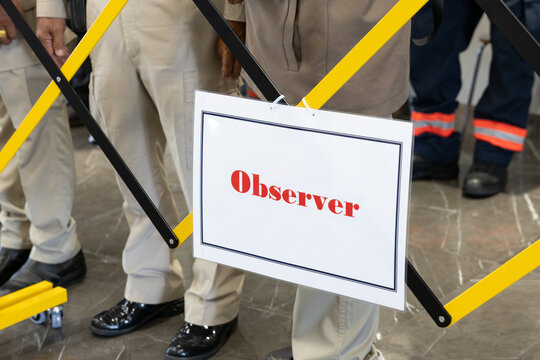 Observer sign on a yellow and black safety barrier