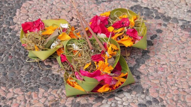 Canang Sari Balinese Hindu Offering with Incense on Stone Ground