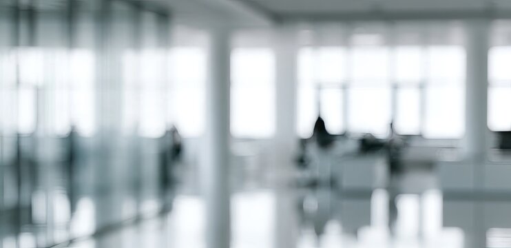 Blurred modern office interior with bright windows and reflective floor