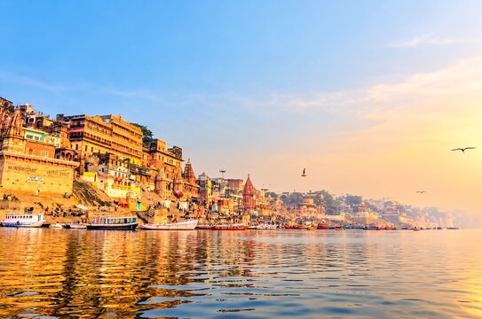 Golden sunrise over sacred ganges river with ancient buildings and ghats along the riverbanks in varanasi