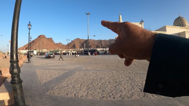 Scenic view of Sayyid al-Shuhada Mosque and Mount Uhud in Medina with pilgrims and pigeons.
