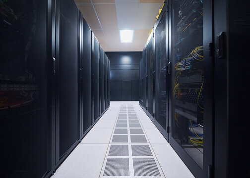 Symmetrical server racks in modern data center with leading aisle perspective