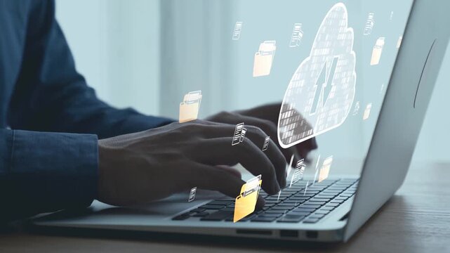 Close-up of hands typing on a laptop with digital cloud storage icons and file folders, showcasing technology and data management concepts in a modern workspace. Qubit.